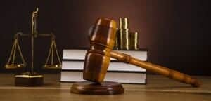 Law books, scales of justice, gavel and stacks of gold coins.