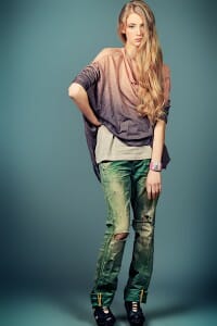 Woman in a tie-dyed shirt and torn blue jeans.