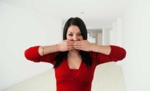 Woman with her hands covering her mouth. She doesn't want to make divorce announcements.