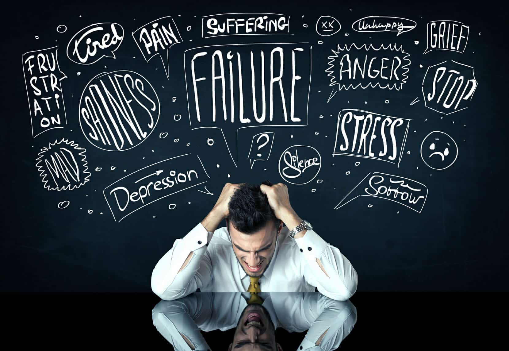 Young depressed businessman sitting under white drawn trouble thought boxes