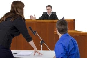 defendant with lawyer speaking to a judge in the courtroom