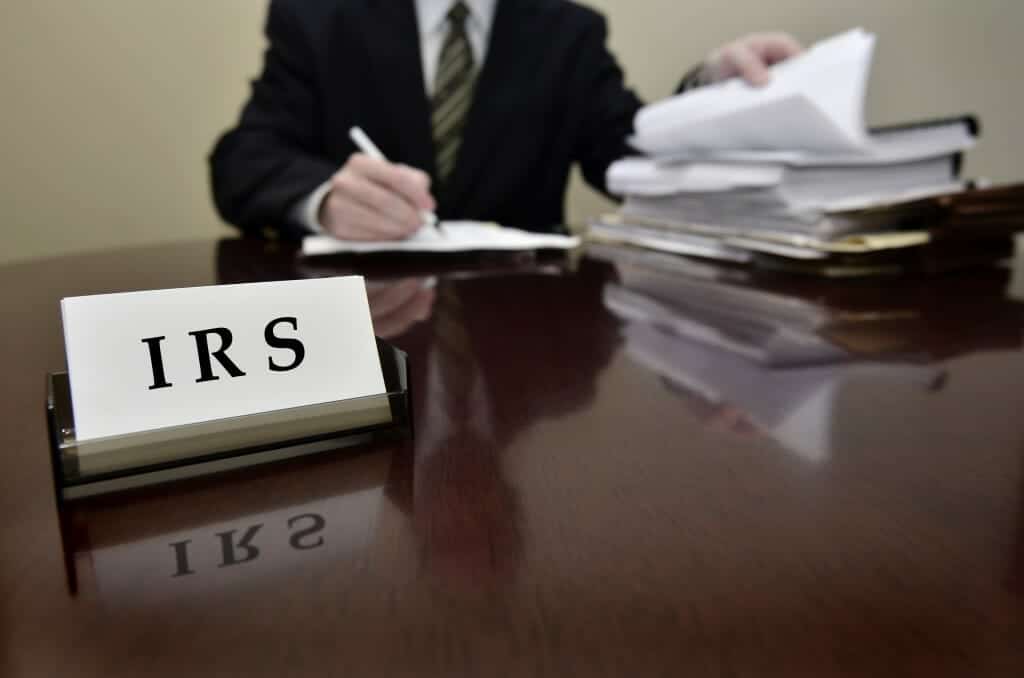 IRS auditor with stack of documents.