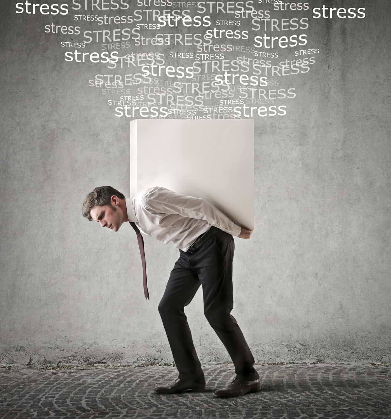 Business man carrying a white box with "stress" words floating above it.