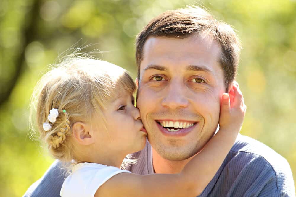 Child kissing her father