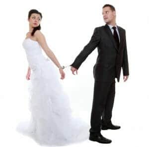 Bride and groom handcuffed together.
