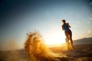 Young lady taking care of herself in divorce, running in a desert at sunset.