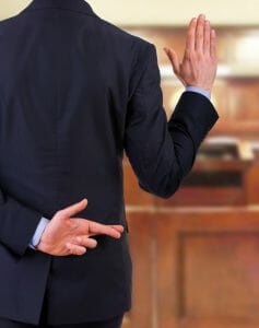 Man in court swearing to tell the truth while having his fingers crossed behind his back - lying in court