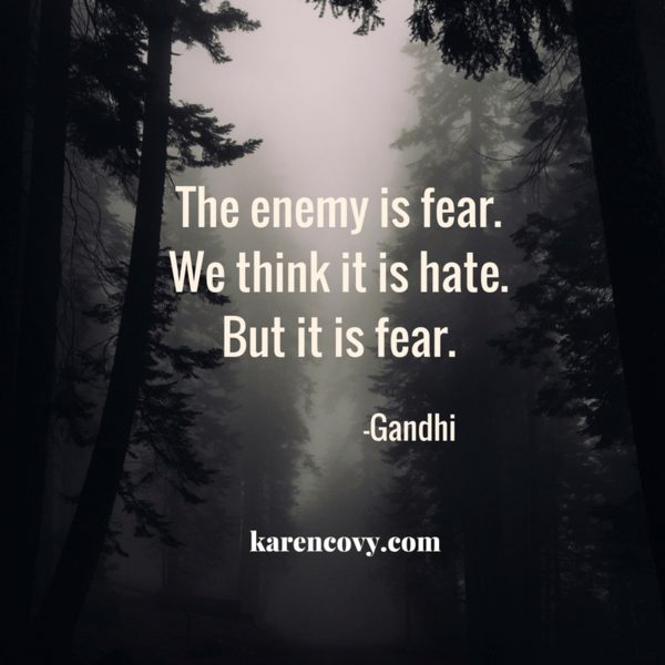 Foggy forest with Gandhi quote: "The enemy is fear. We think it is hate. But it is fear."