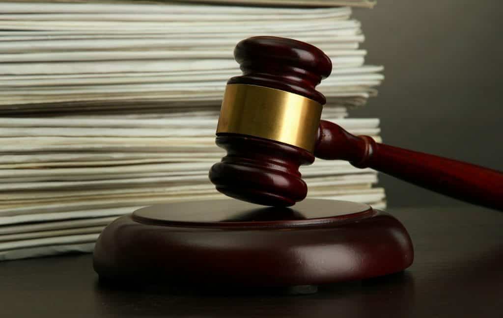 Gavel in front of a stack of court orders (documents)