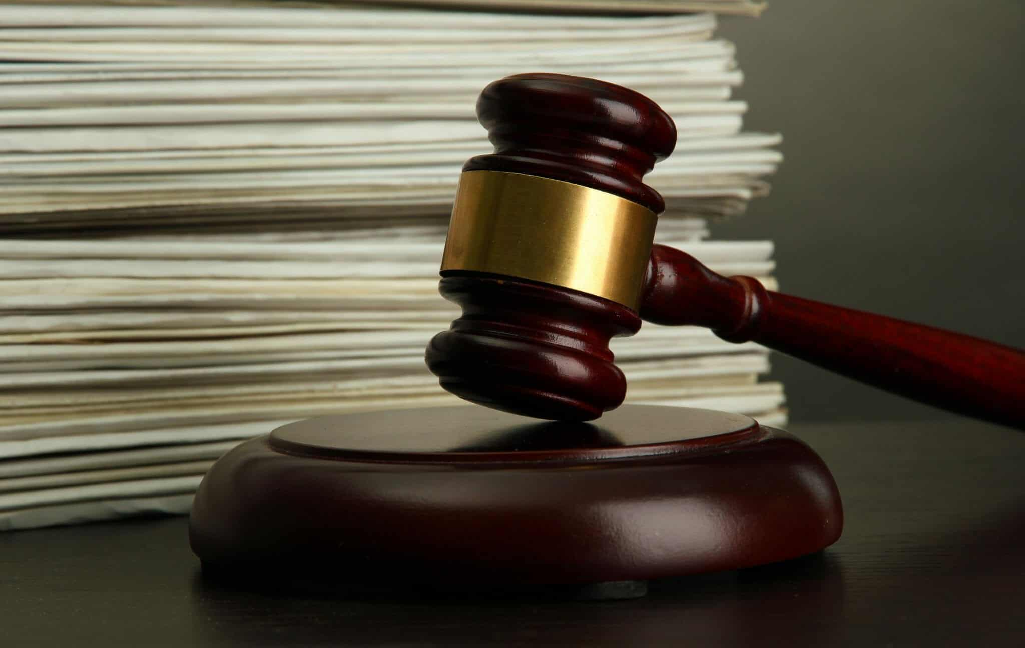 Gavel in front of a stack of court orders (documents)