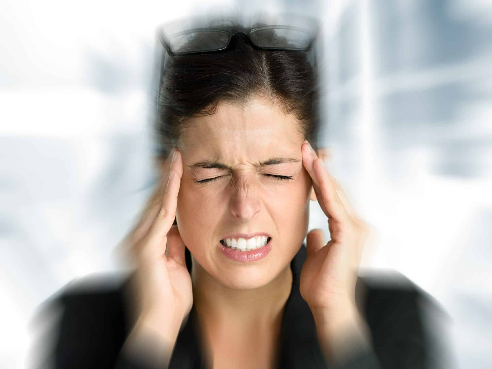 Pretty woman holding her head in pain from the stress of a bad marriage.