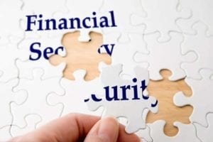 Hand holding a piece to complete puzzle with the words "financial security"