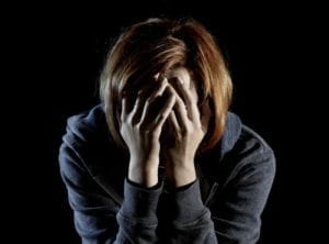 Woman dealing with heartbreak holding her face in her hands