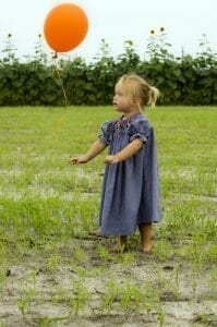Cute, small girl showing how to let go of a balloon.