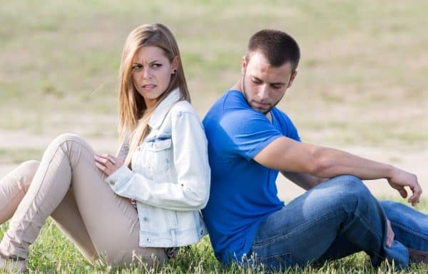 Upset married couple sitting back to back thinking about a trial separation.