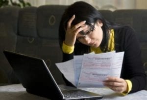 Frustrated woman reviewing tax returns trying to figure out the alimony tax deduction.