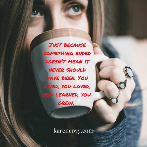 Sad woman drinking coffee from a cup with inscription: "Just because something ended doesn't mean it never should have been."
