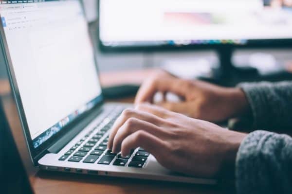 Man's hands typing on laptop computer