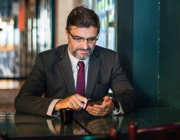 Middle aged male lawyer on social media on his phone