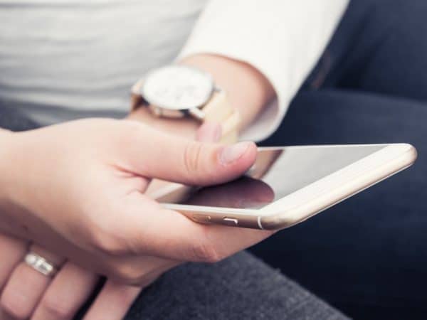 Close up of hands on a phone looking at co parenting apps