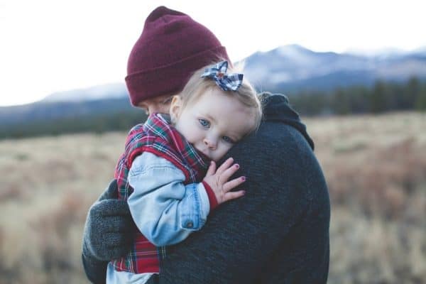 Parent holding beautiful baby girl while hiking in the mountains. This is what parenting after divorce looks like.