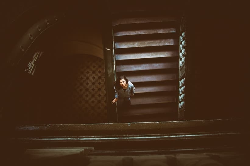 Beautiful woman lookin up from the bottom of a stairway, signifying how to let go.