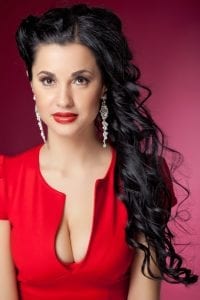 Beautiful woman in lowcut red dress and dangling earrings showing what not to wear to court.