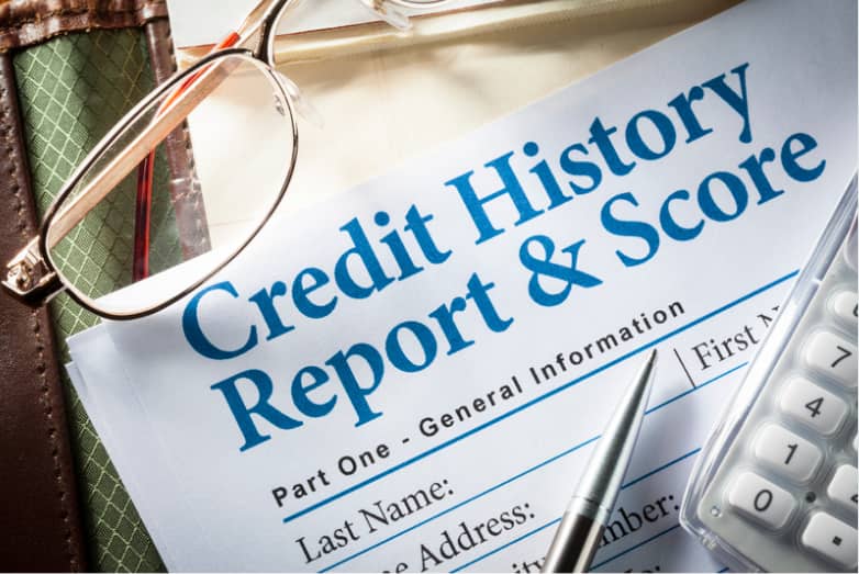 Picture of a Credit Report with reading glasses and a calculator.