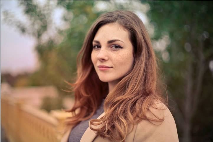 Young woman with long brown hair looking at the camera