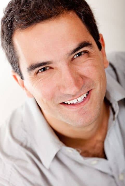 Happy Man with dark hair smiling into the camera.