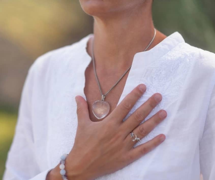 Woman with her hand over her heart denoting honesty.