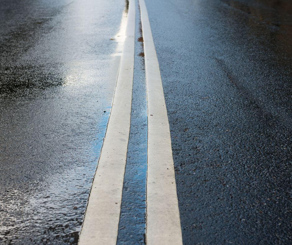 Double yellow line on a road signifying boundaries.