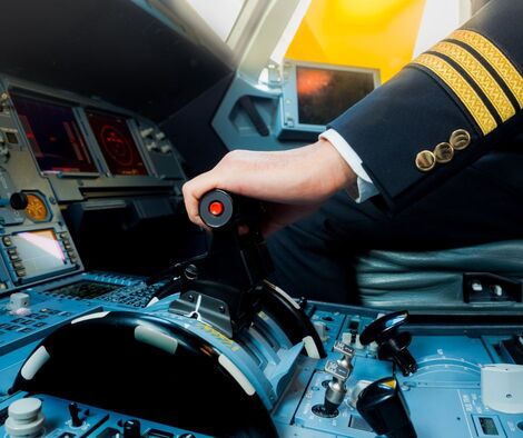 Pilot's hand on the controls in the cockpit of an airplane. Put yourself in control.