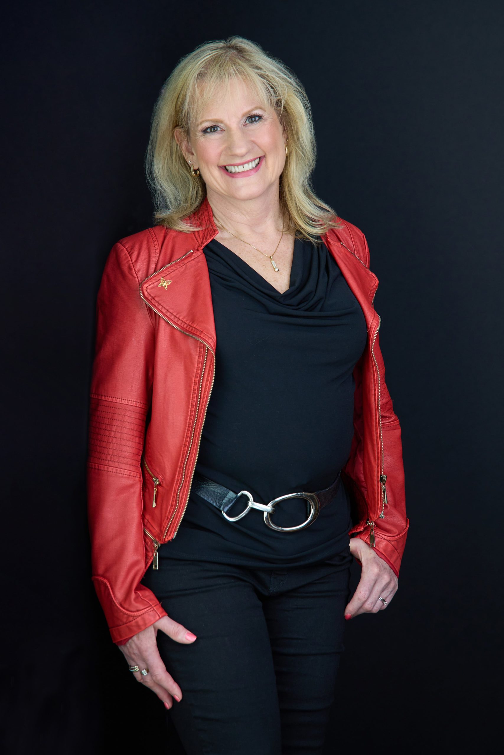 Standing picture of Karen Covy in an orange leather jacket.