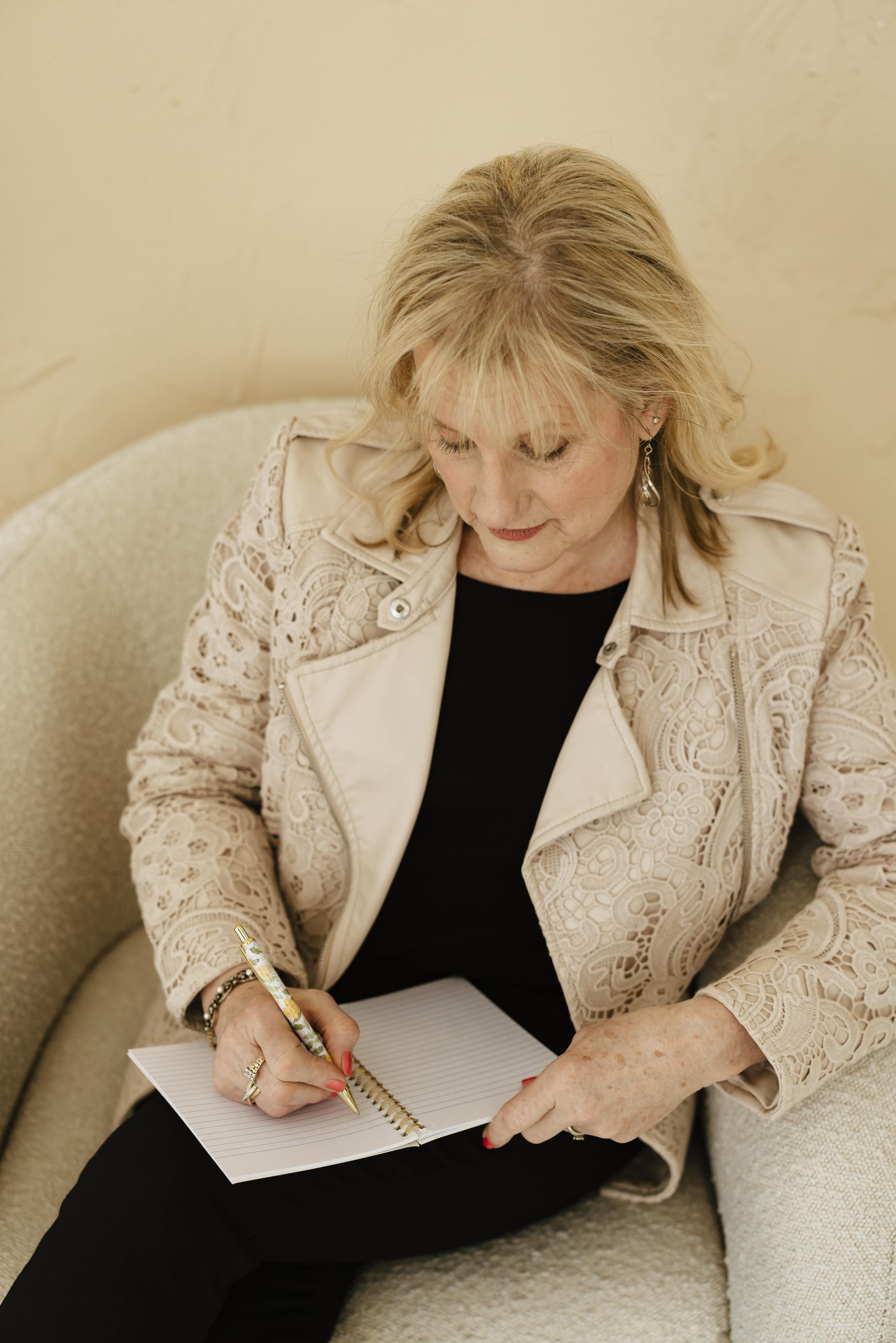 Karen Covy looking down and taking notes in a coaching session.
