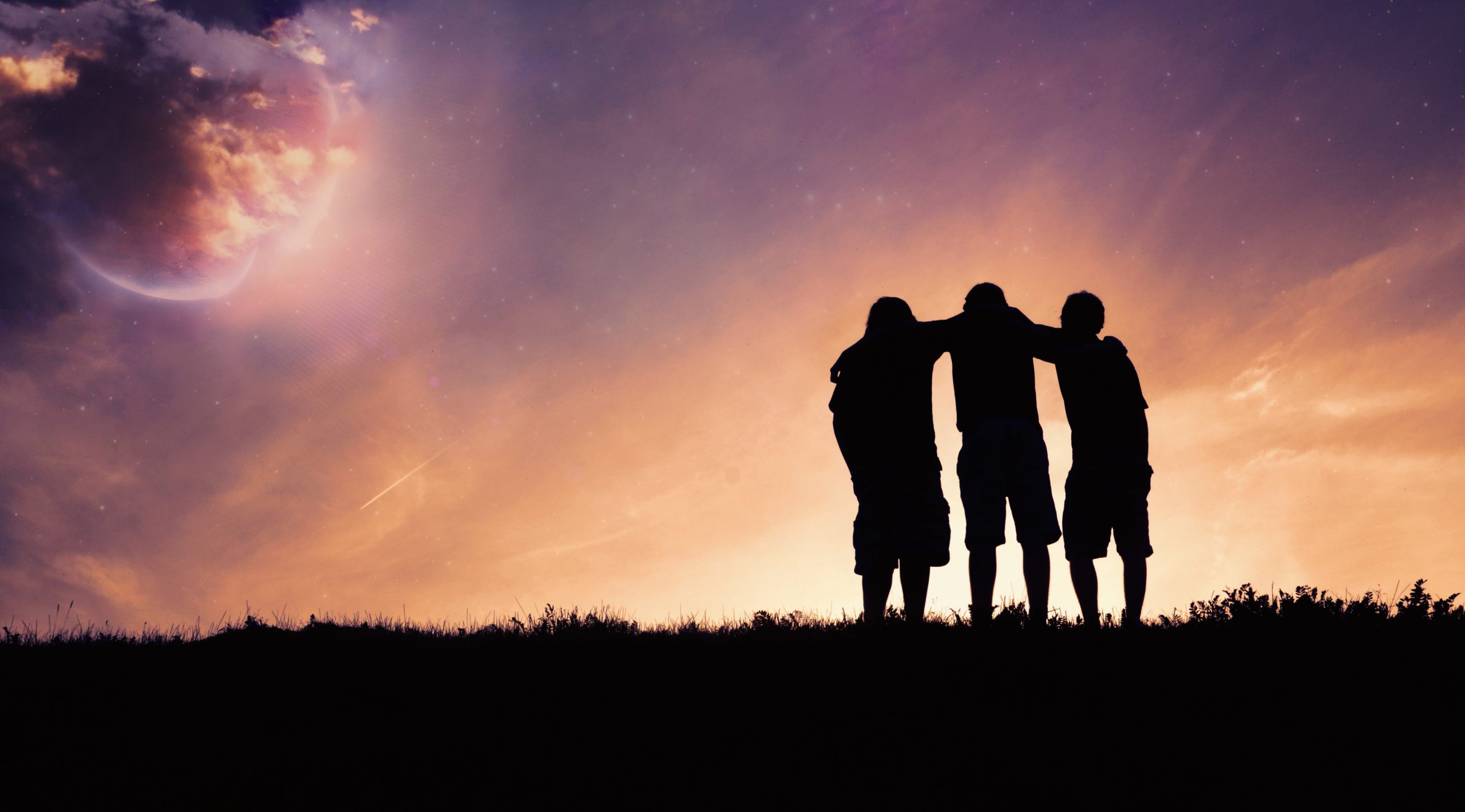 Silhoutte of 3 friends with arms around their shoulders at dusk.