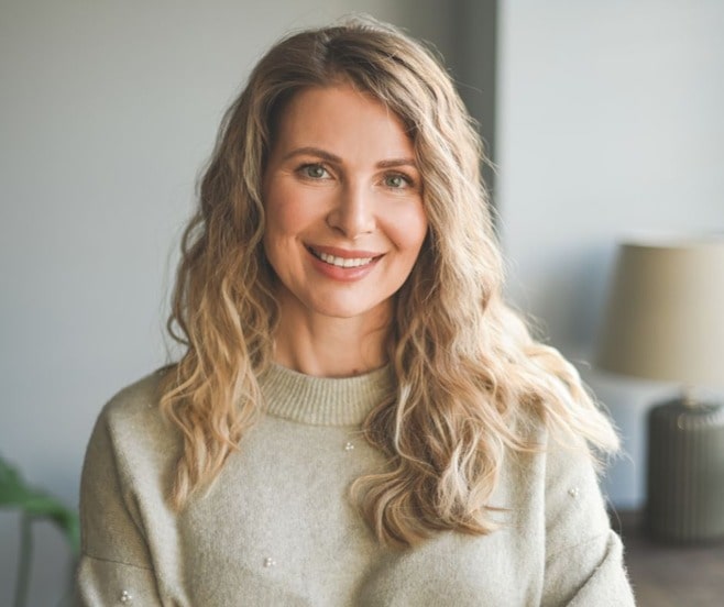 Smiling woman with long blonde hair in her mid 40s.