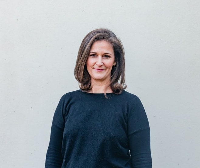 Practical looking middle aged woman in a blue sweater.