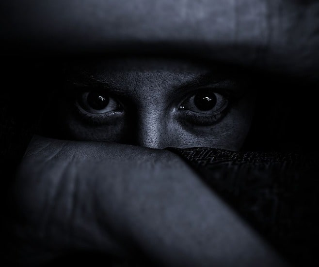 Black and white photo of eyes in a rear view mirror, symbolic of fighting your fears.