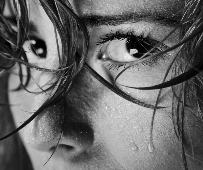 Black and white photo of a womans eyes who is scared to divorce looking at the camera.