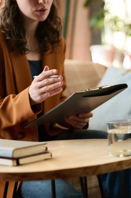 Young therapist with a clipboard talking with a divorce client.