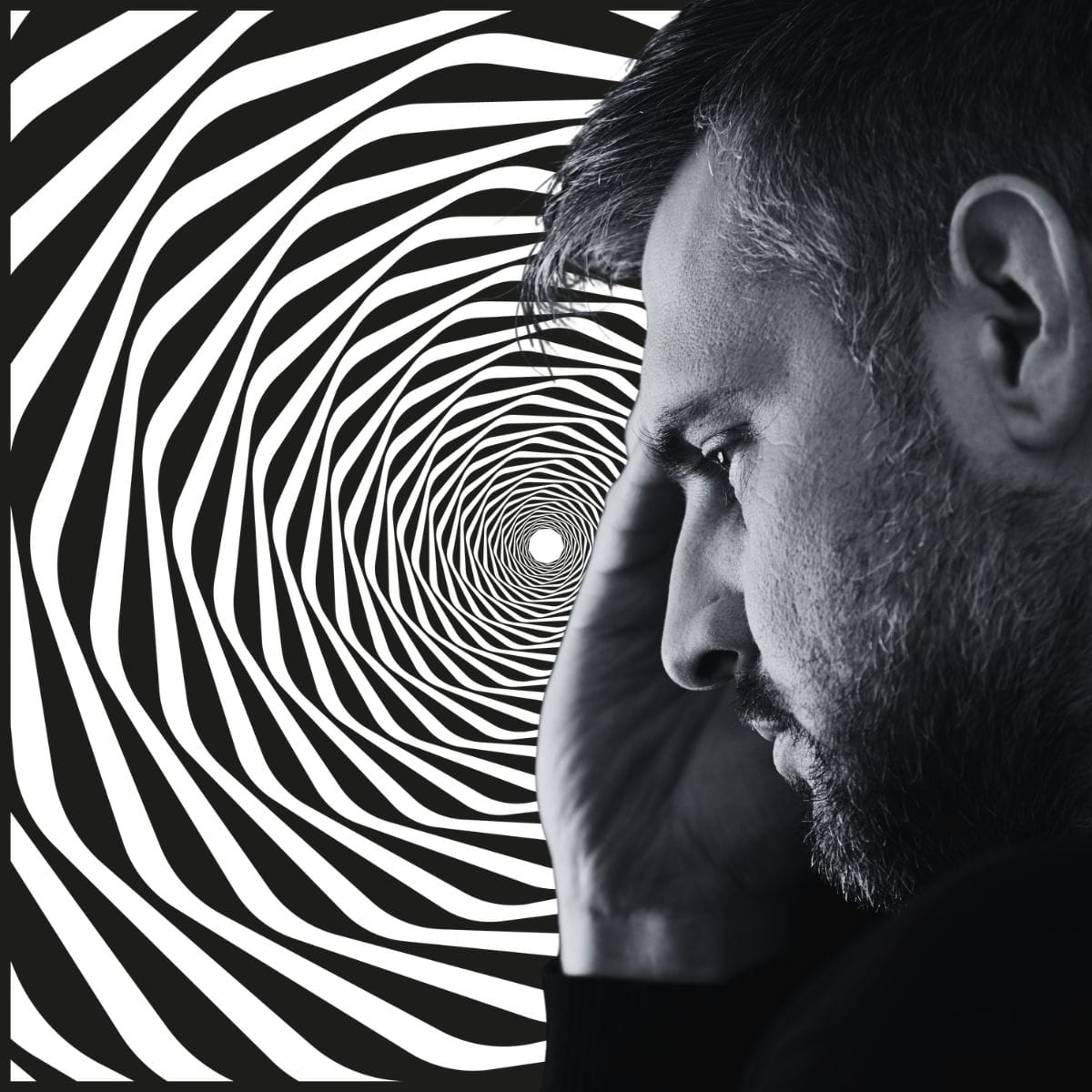 Black and white image of a man in front of a spiral, signifying spirally emotions.