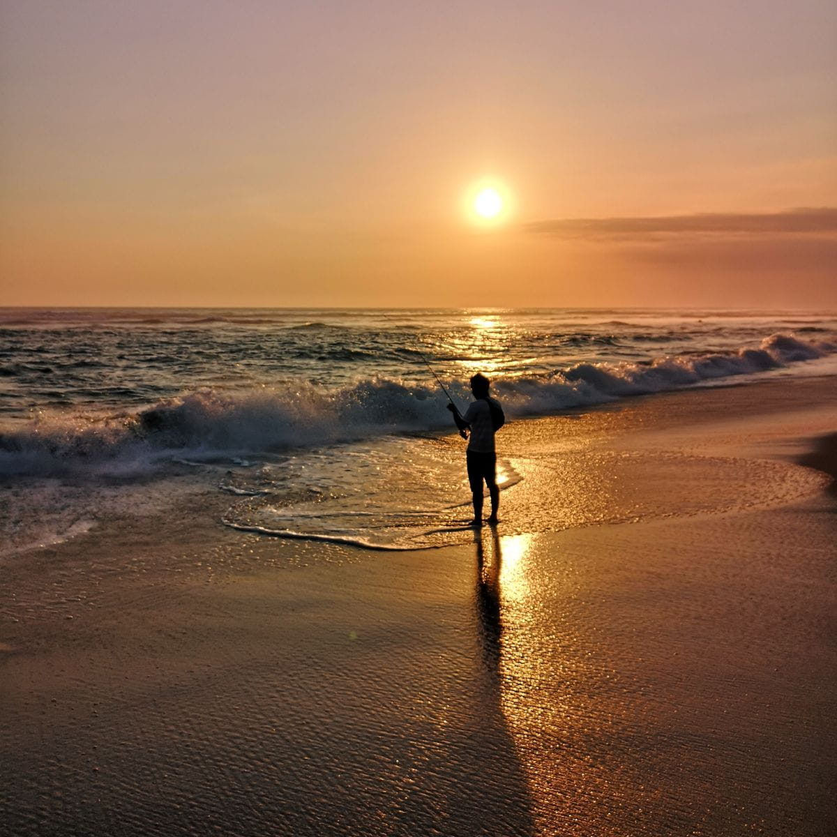How to Let Go: Person with outstretched arms on a beach at sunrise.